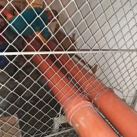 Szennyvíz elvezető csövek rácsos védőburkolat mögött